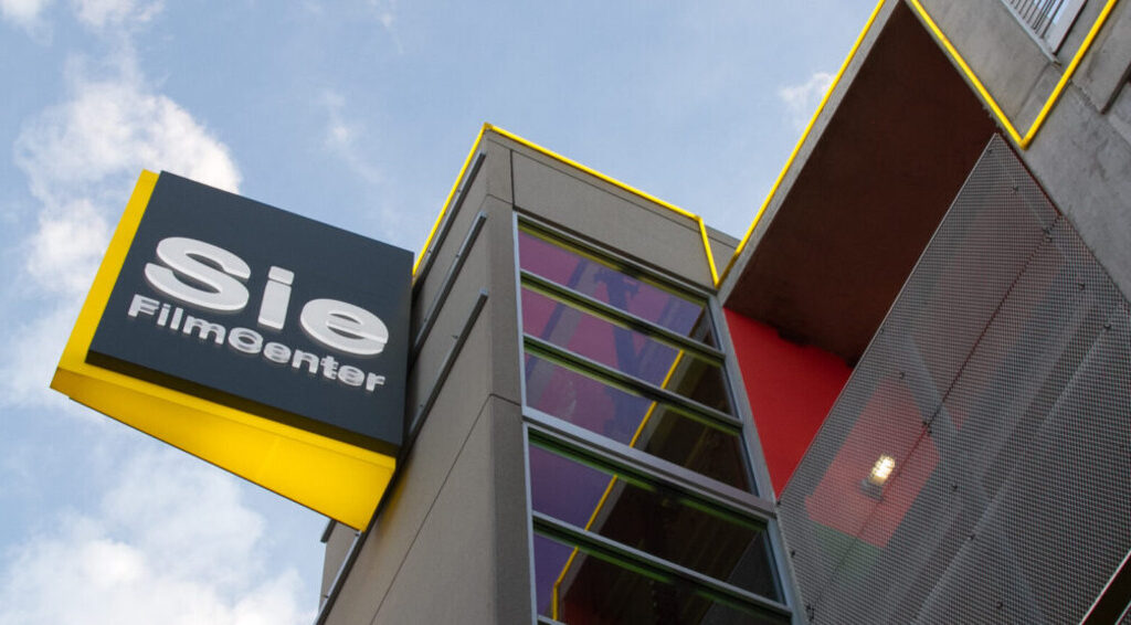 Sie FilmCenter sign with yellow trim on modern building facade