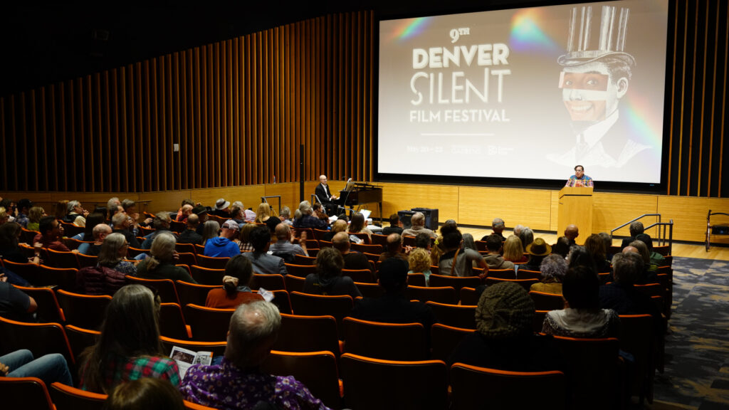 Audience seated in a theater listening to a speaker at the 9th Denver Silent Film Festival, May 20-22