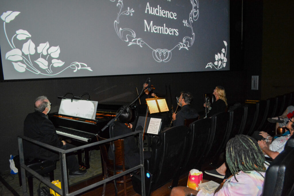 DSFF_2023-3.jpg shows musicians playing before a screen displaying "Audience Members" with decorative floral designs
