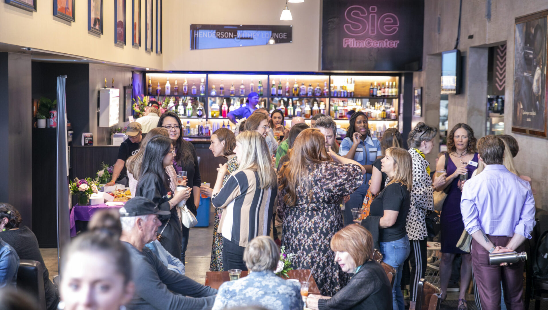 People socializing at Henderson-Withey Lounge, Sie FilmCenter, during an event mixer