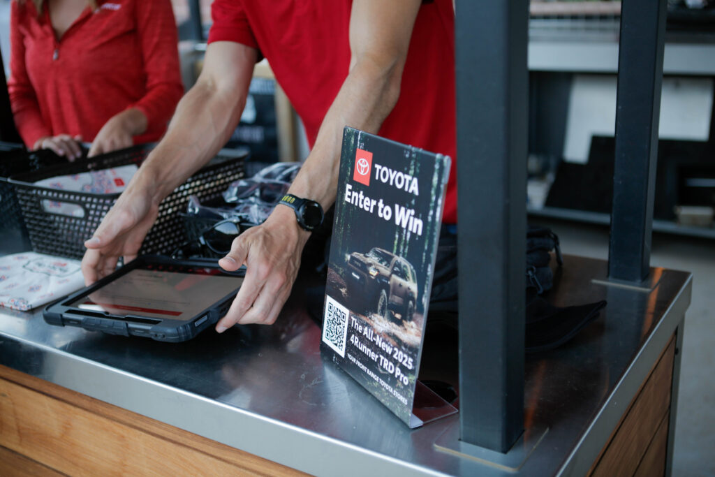 Toyota booth offering contest entry, person holding tablet