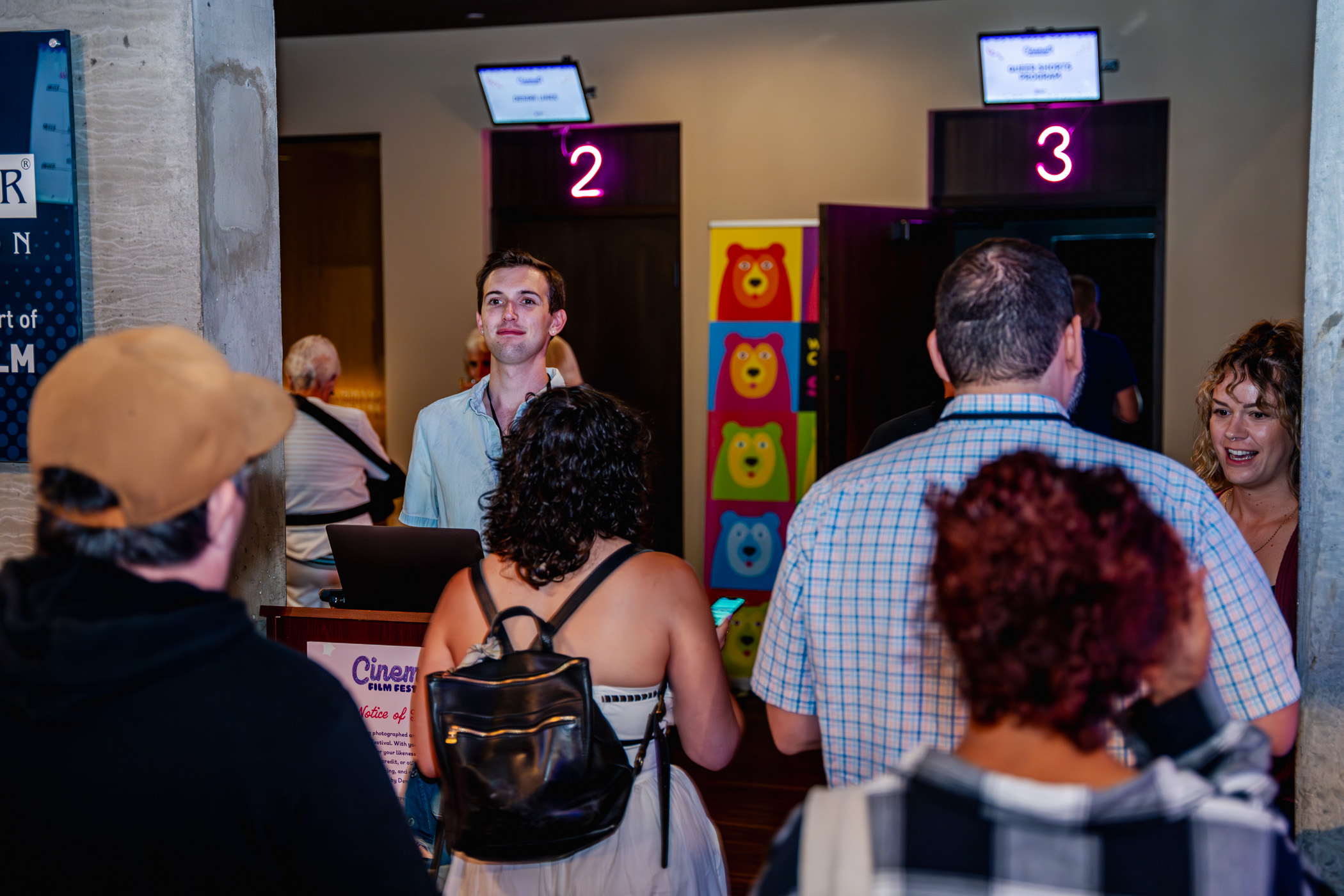 People queue at a film festival entrance, Cinema Day 3, screen 2 and 3 signs visible