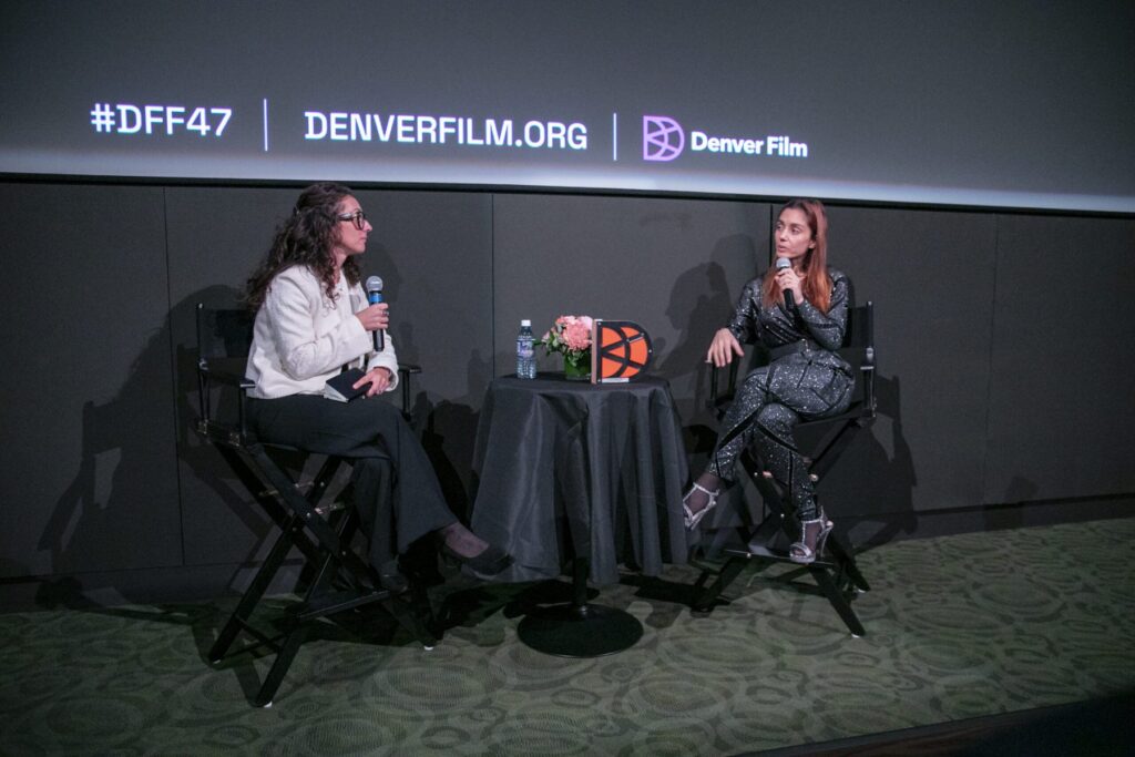 Two women in a discussion, seated on stage with microphones, at Denver Film event #DFF47