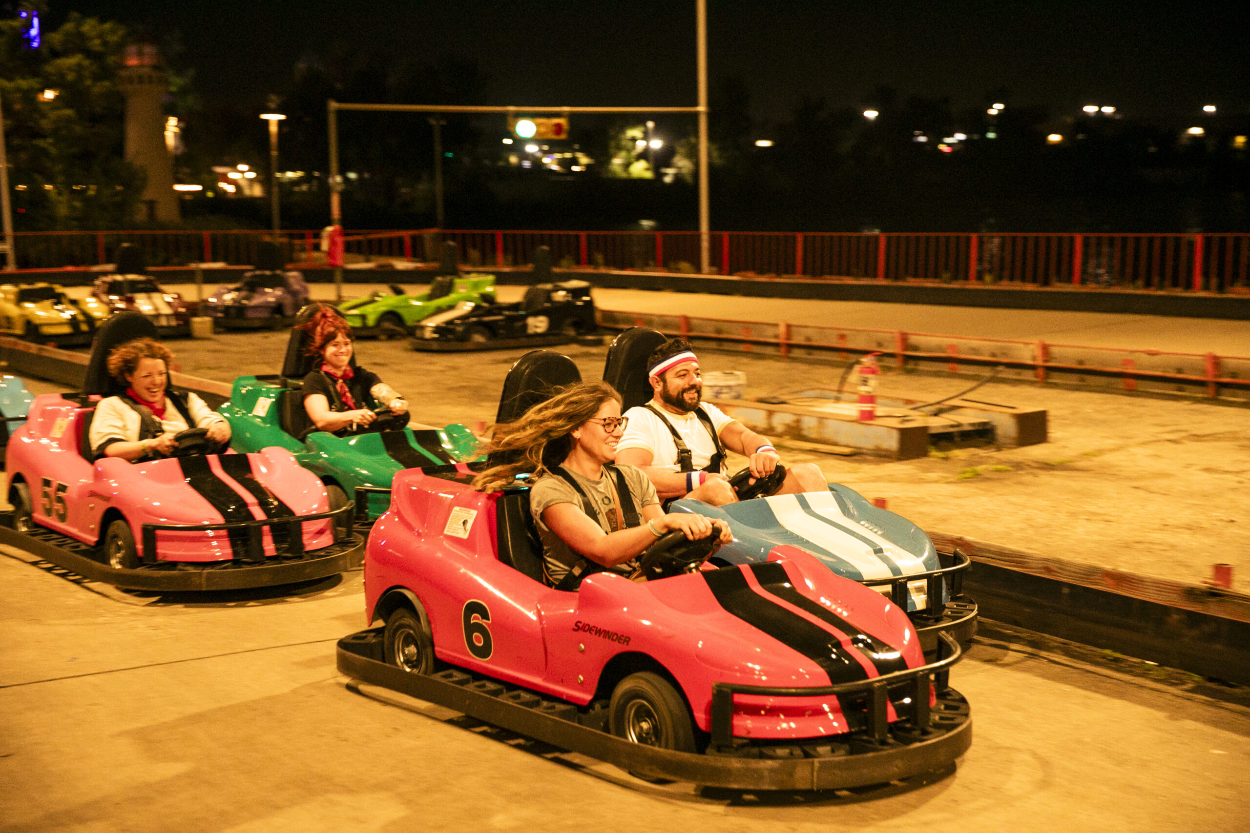 DeWitt enjoying a nighttime go-kart race with friends, smiling energetically