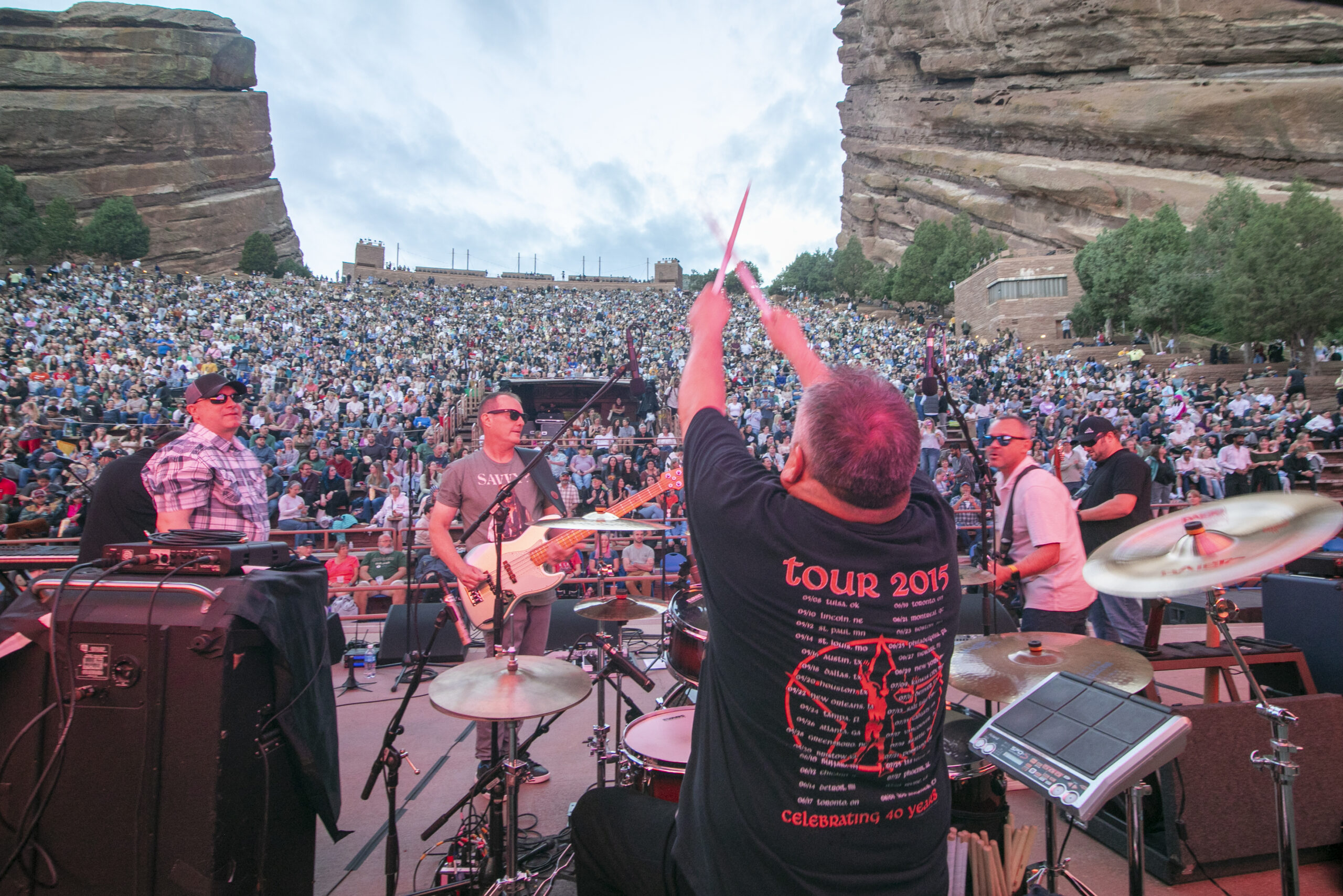 Musicians performing at an outdoor concert with a large audience