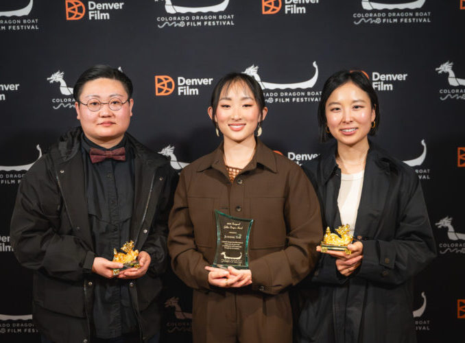 Three people holding awards in front of a Denver Film Festival backdrop
