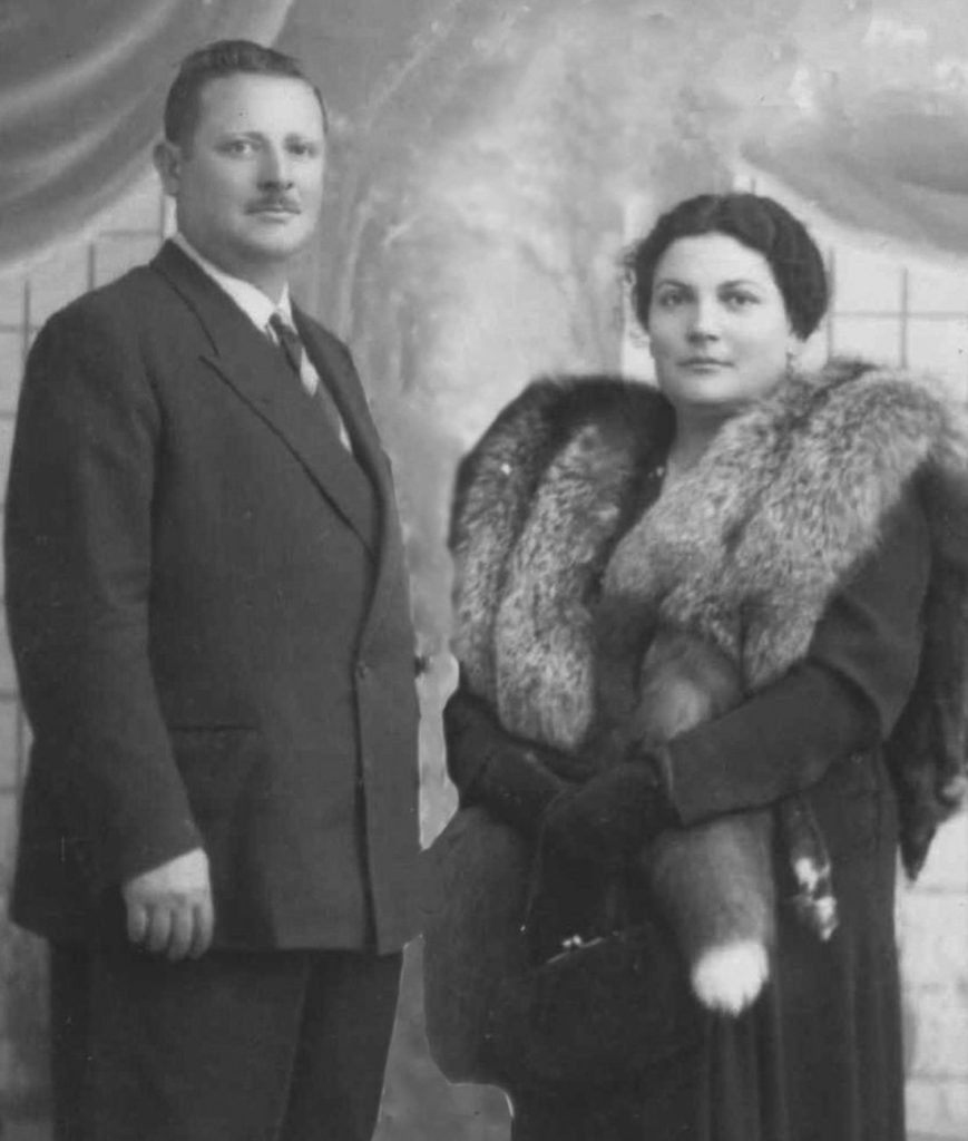 A man and woman in formal attire, woman wearing a fur stole