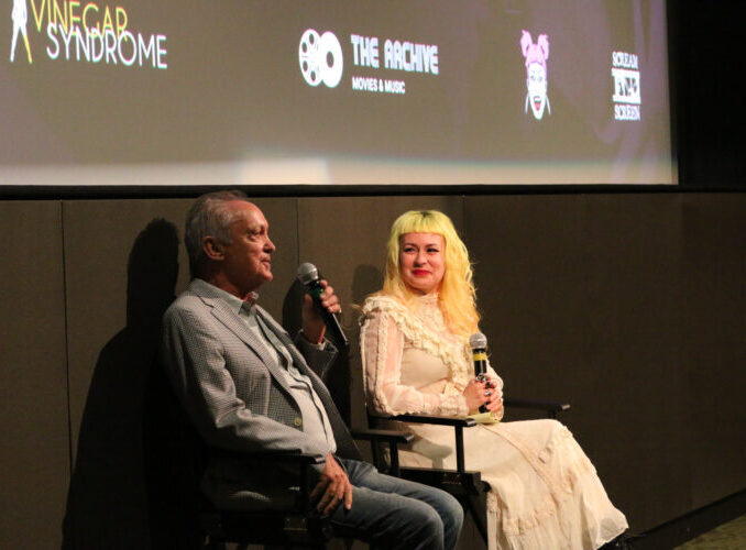 Two people seated and speaking at CinemaQ 2023 event. Logos: "Vinegar Syndrome," "The Archive," "Scream Screen"