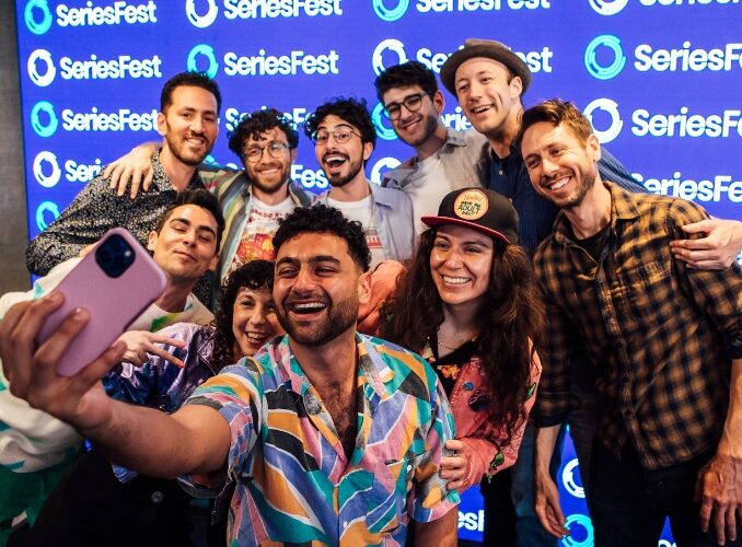 Smiling group selfie at SeriesFest, vibrant backdrop, joyful mood