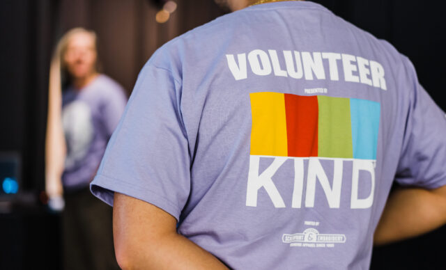 Support-Volunteer-2 in purple shirt with "VOLUNTEER KIND" text and colorful stripes. Logo: From The Hip Photo