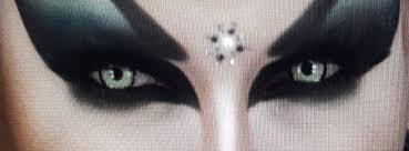 Dramatic makeup with dark eyeshadow and a jeweled forehead design