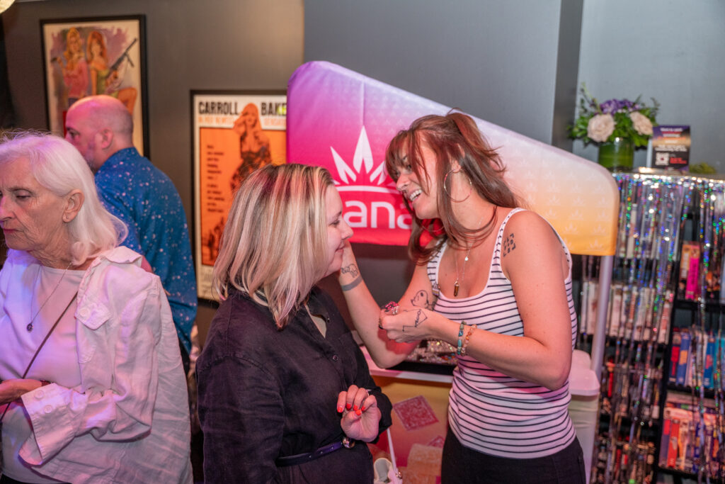 BeauNgu-20 interacting warmly with a woman, colorful festival backdrop, smiling and engaged in conversation