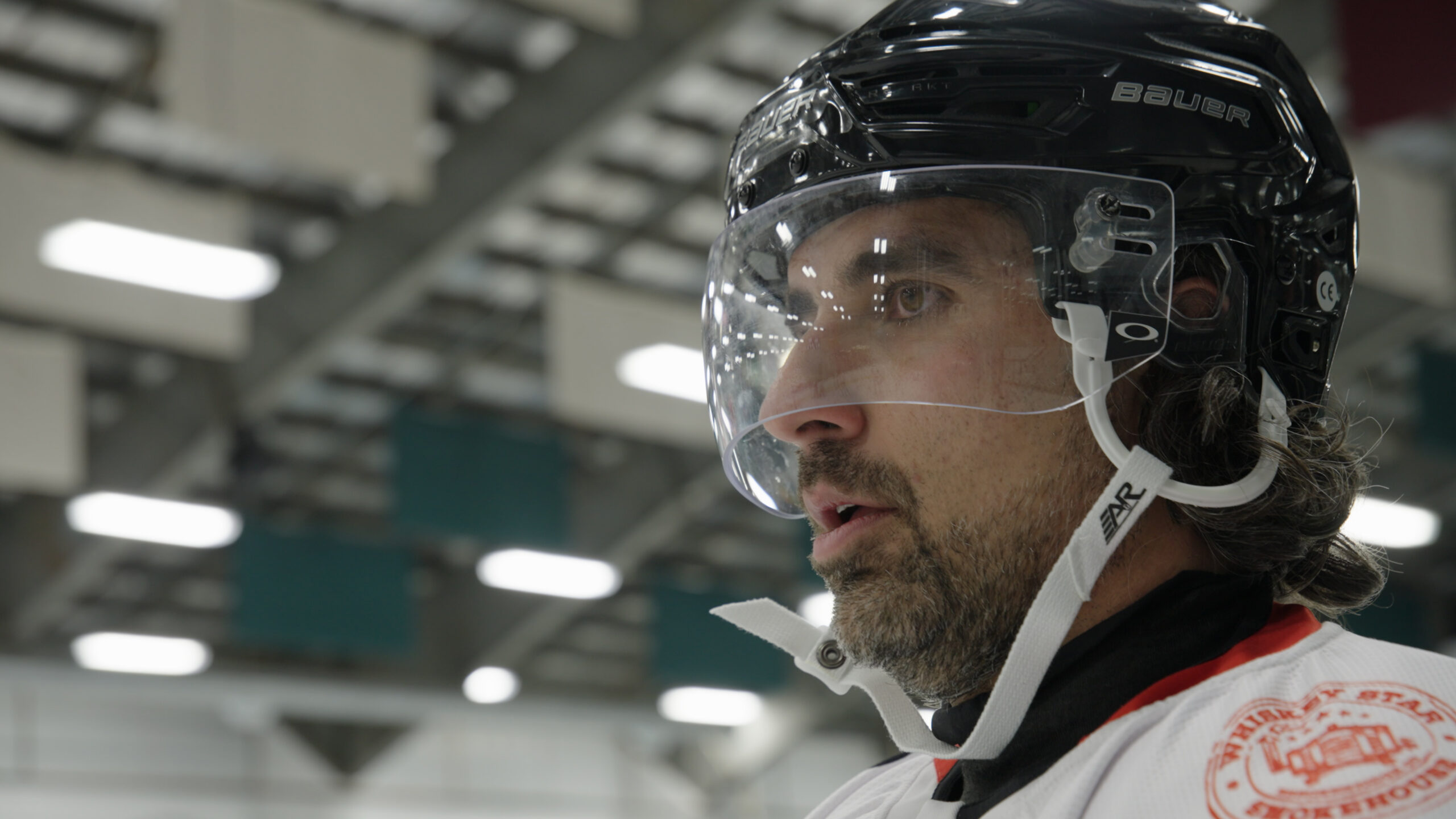 Nick, wearing a black helmet, looks focused during a hockey game