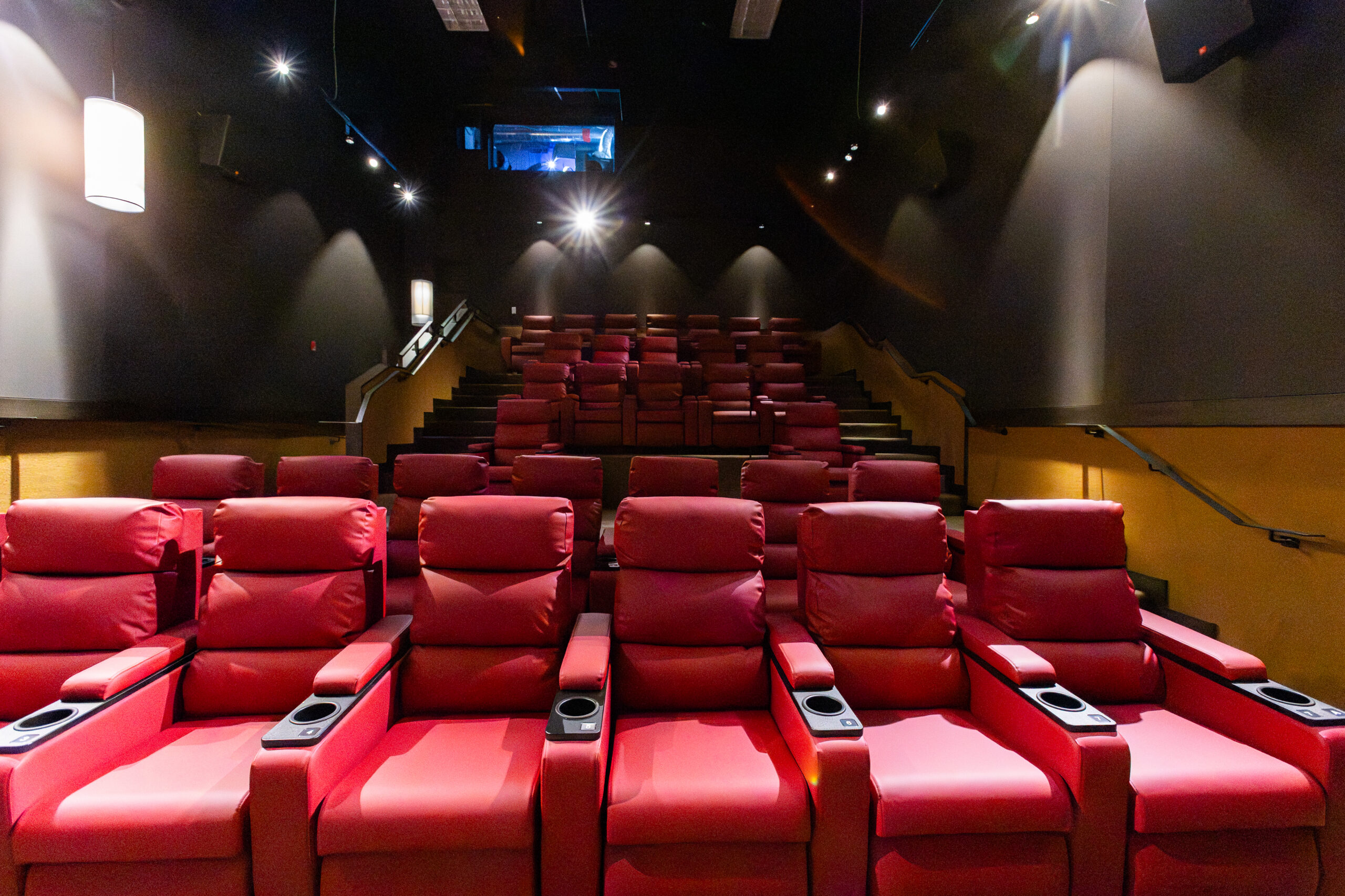 Red recliner seats in an empty modern movie theater auditorium