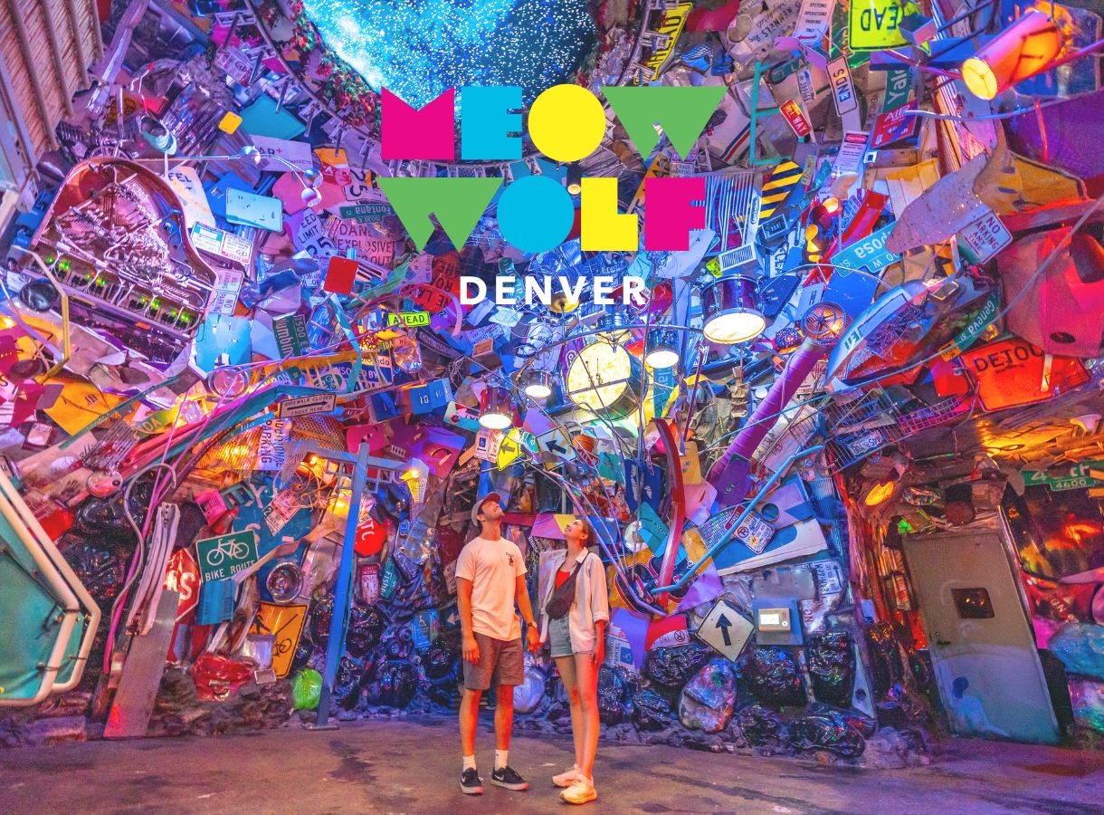 Meow Wolf Denver installation with vibrant colors, random signs, and two people exploring