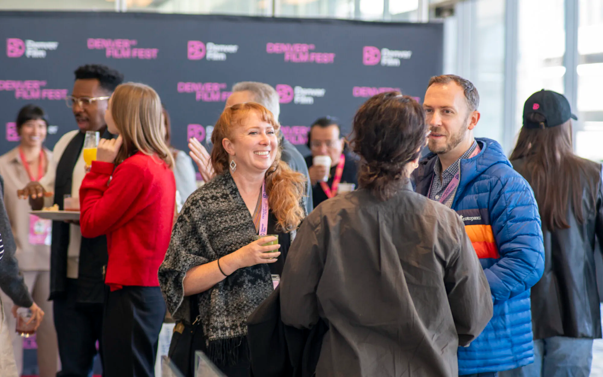 [gpt-4o]: People socializing at Denver Film Fest event backdrop