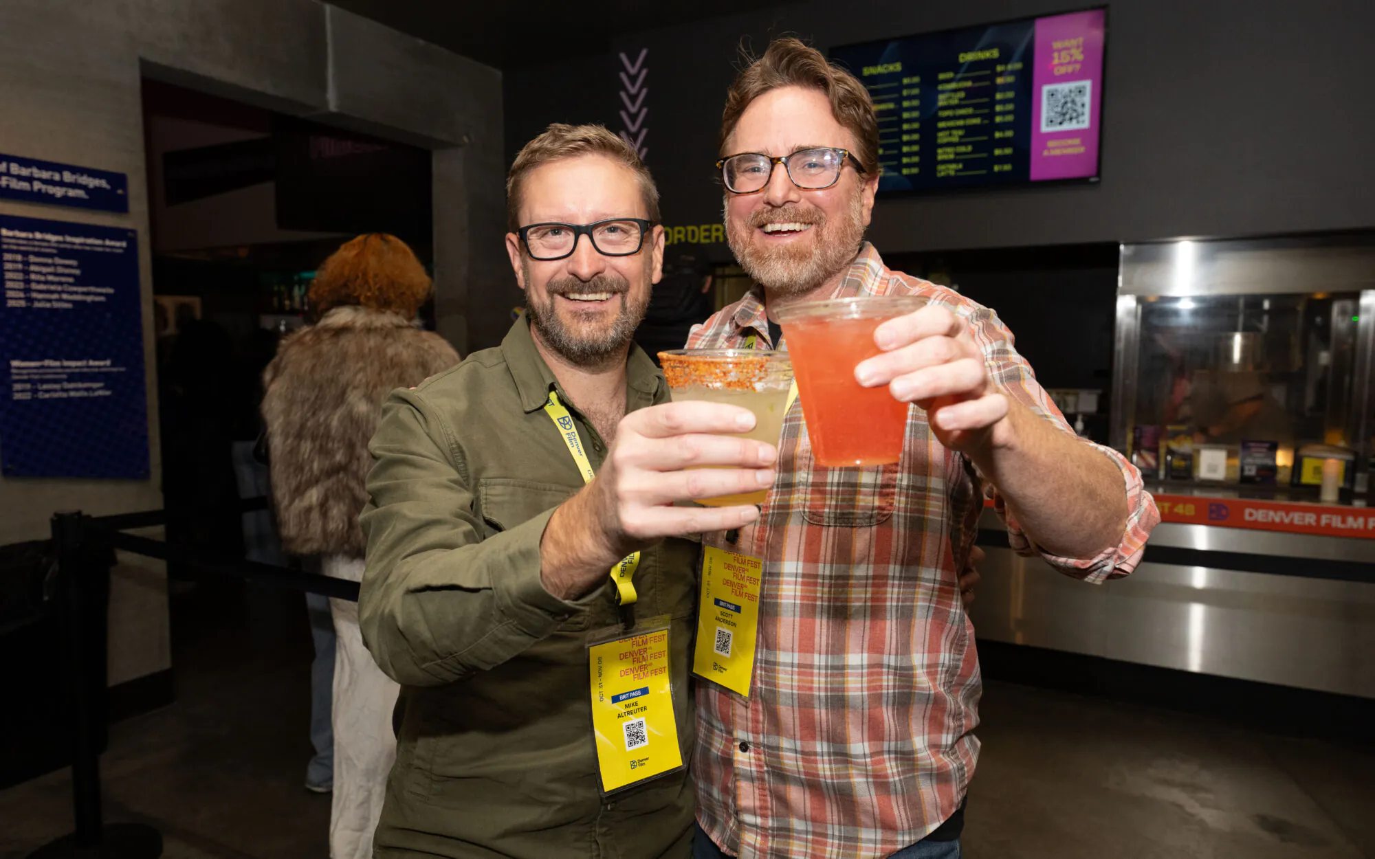 [gpt-4o]: Two men at Denver Film Fest, smiling and holding cocktails